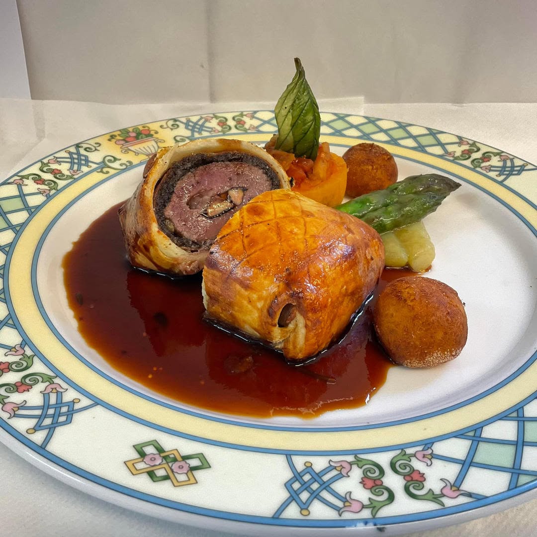 Beef Wellington with asparagus, fondant potato and red wine jus, plated at Chez Moi