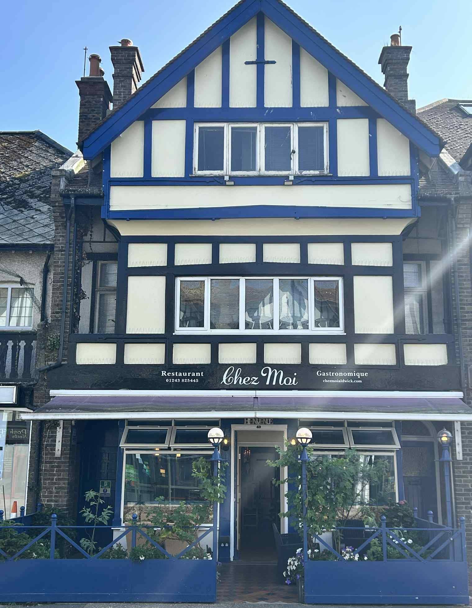 The Chez Moi shopfront on Aldwick Road: blue and cream timbered facade, awning and terrace planters